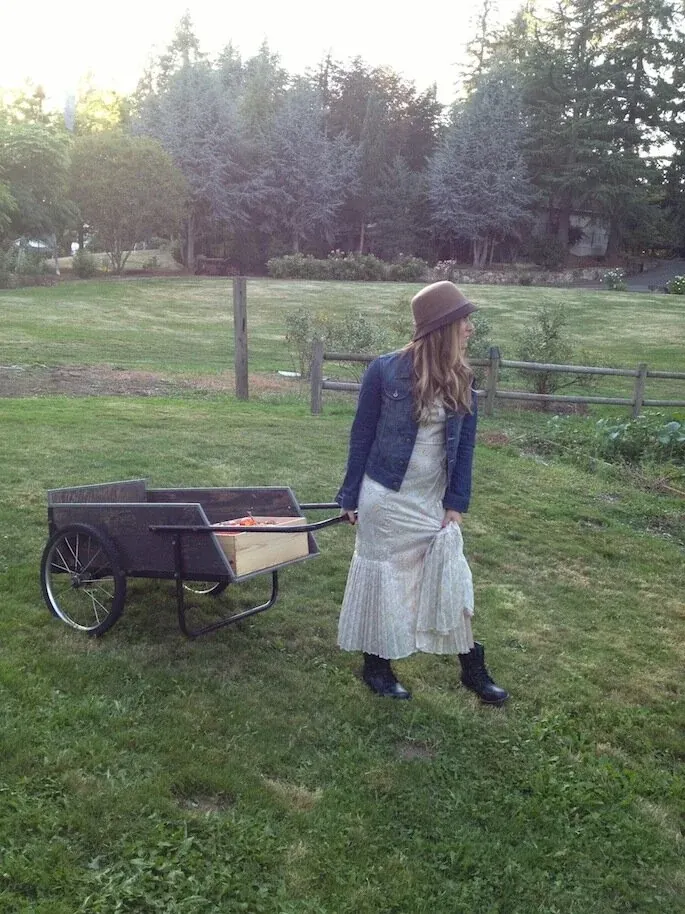 Dr. Michele Burklund in a garden beside a cart of freshly gathered produce